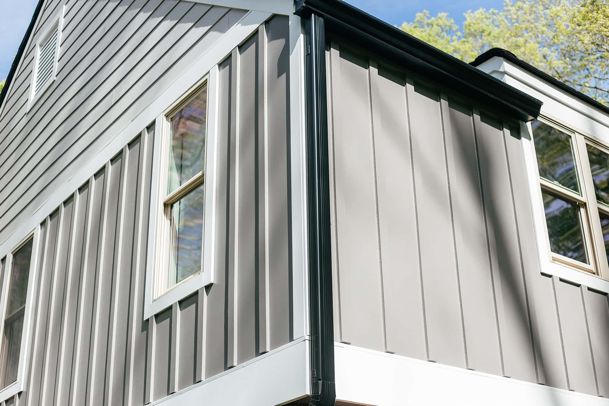 Grey James Hardie fiber cement siding with black gutters
