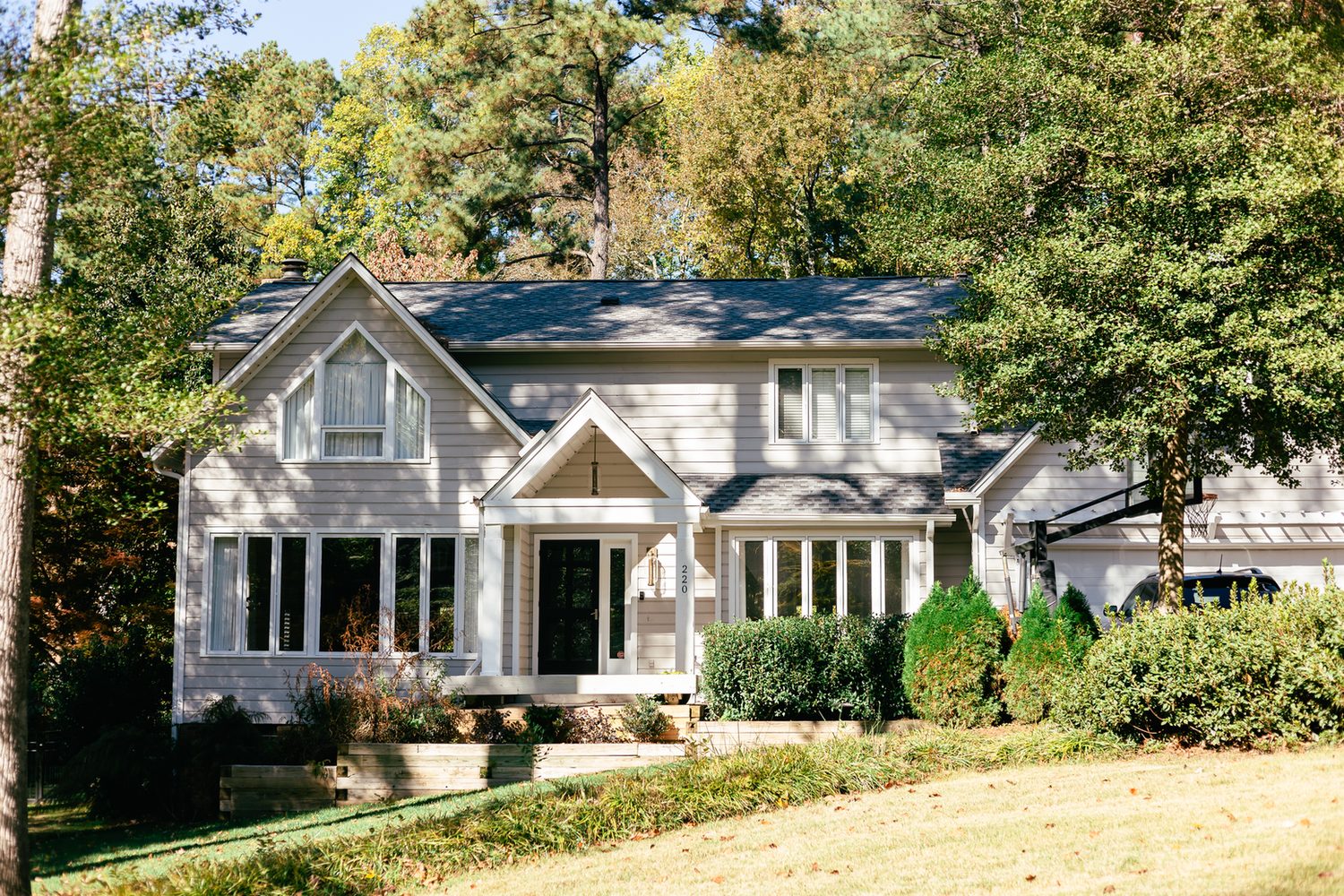 Before: a two-story home in Cary with dated gray lap siding and white trim