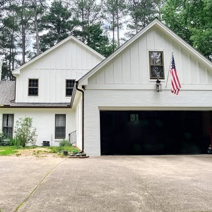 After: white board and batten siding on the same gables, with black windows and a black garage door