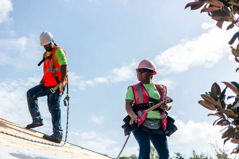 Roofers holding tools during reroof
