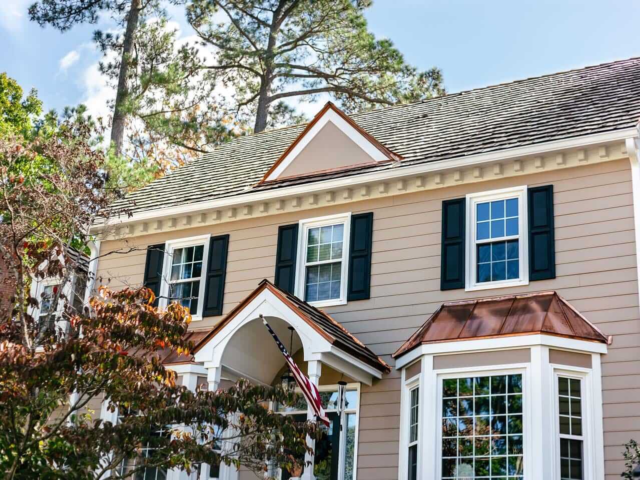 New tan siding installation on two-story family home