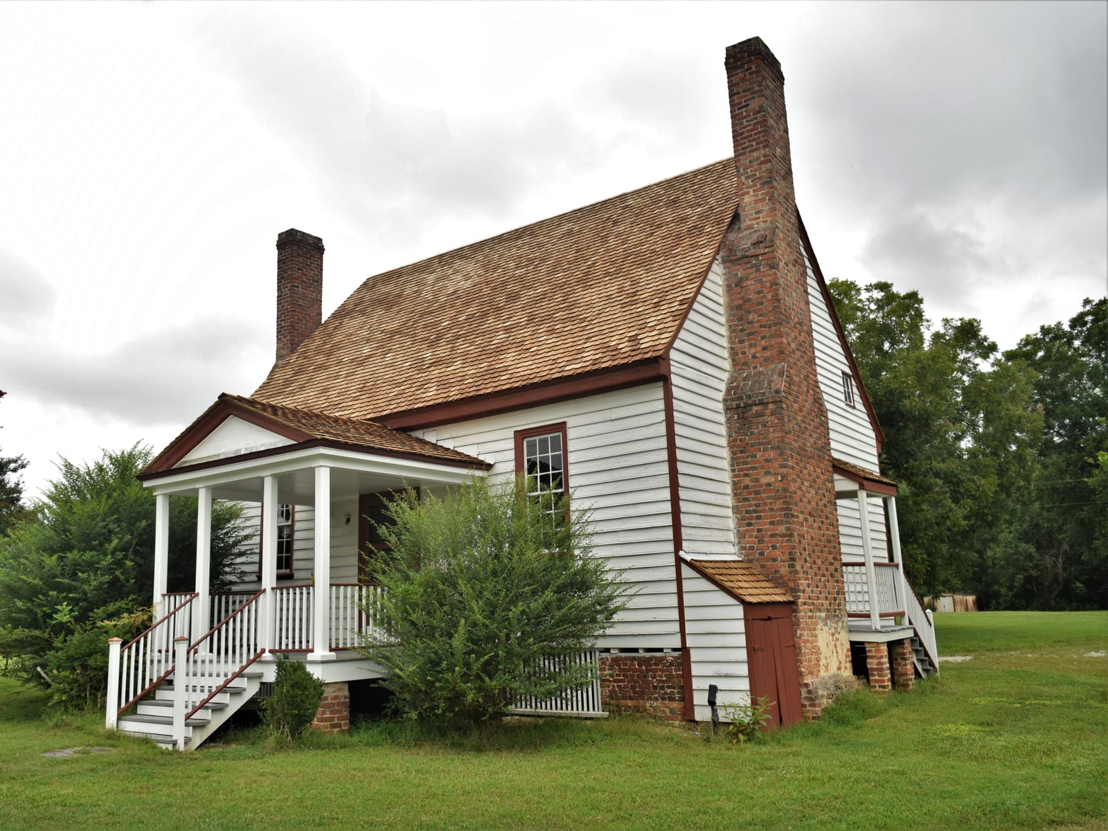 New cedar shingle roof on a white farmhouse built in 1703, with brick chimneys and a front porch