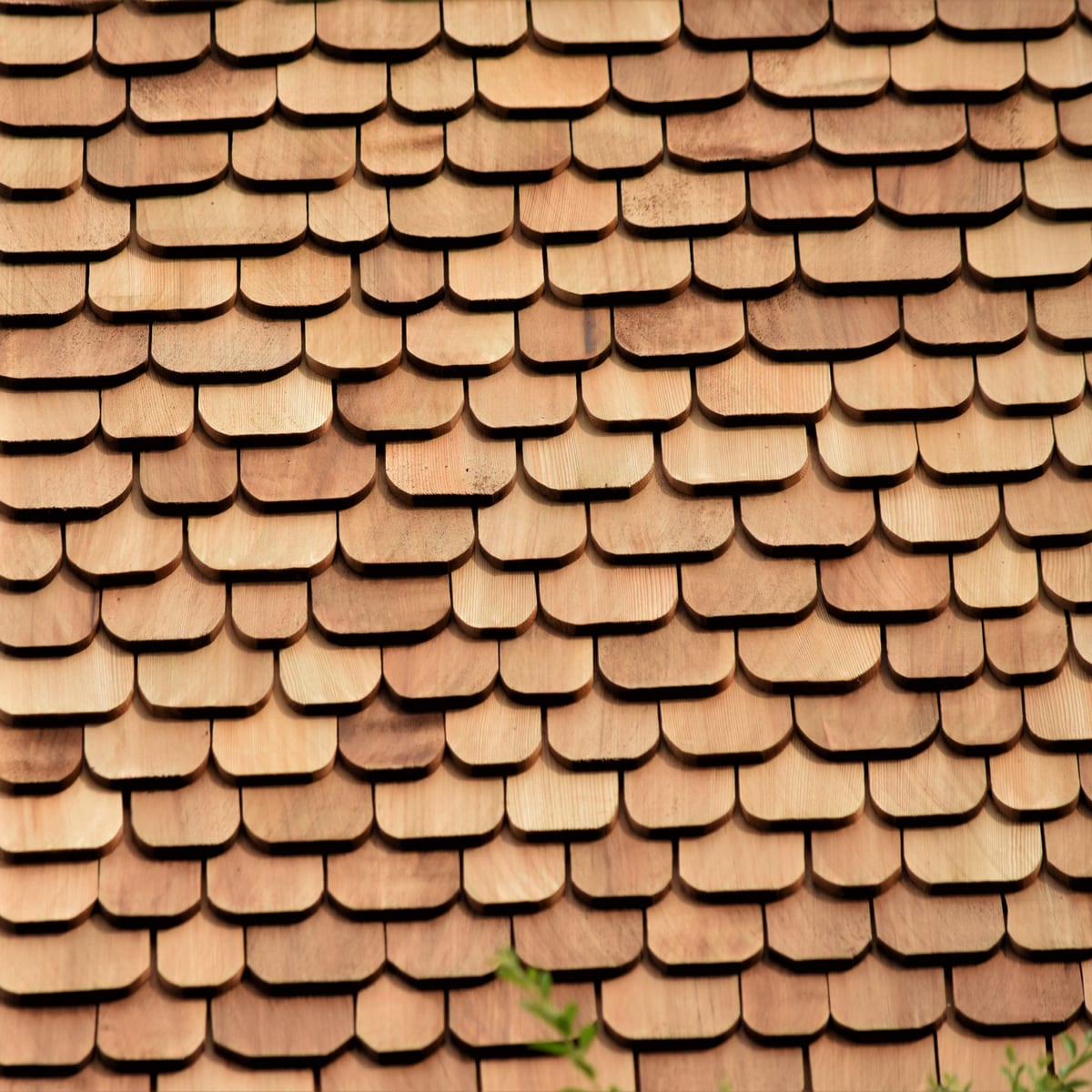 Cedar shingles meeting an old brick chimney on a historic farmhouse