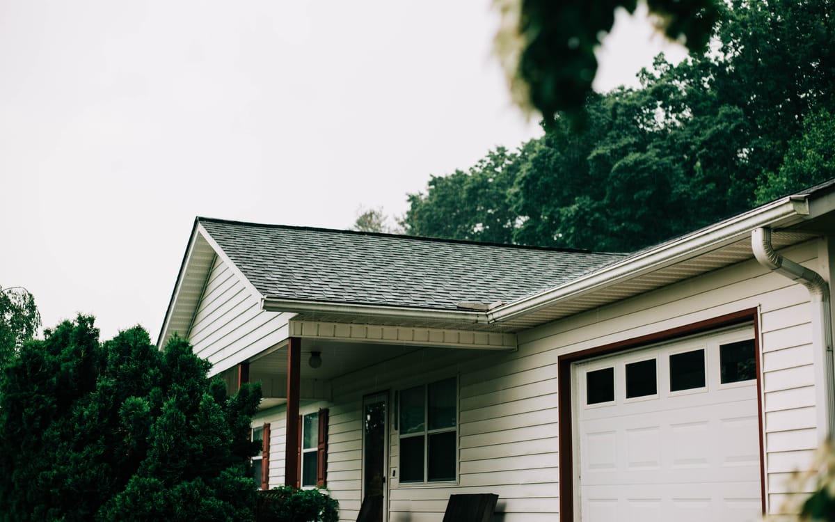Shingle roof on a white ranch home with a garage