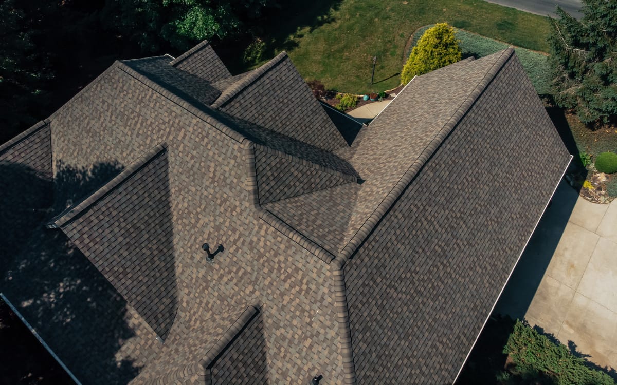 Aerial view of a brown shingle roof with several valleys and hips
