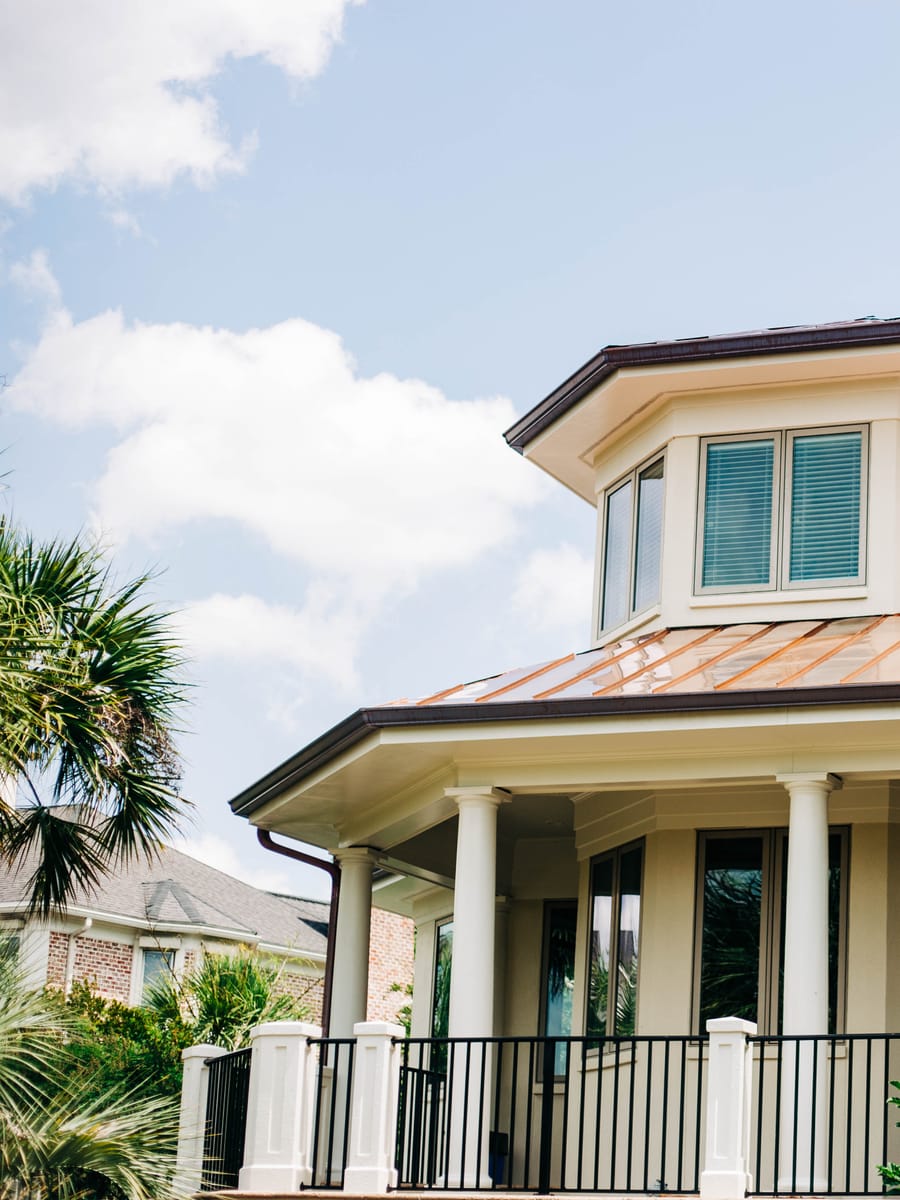 Copper porch roof on a Lowcountry home with columns and palmettos