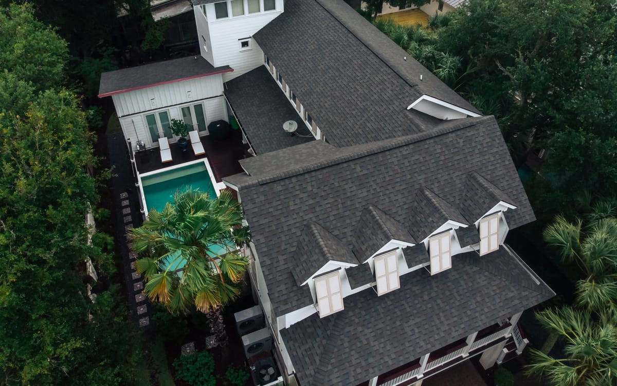 Architectural shingle roof with dormers above a courtyard pool on Isle of Palms