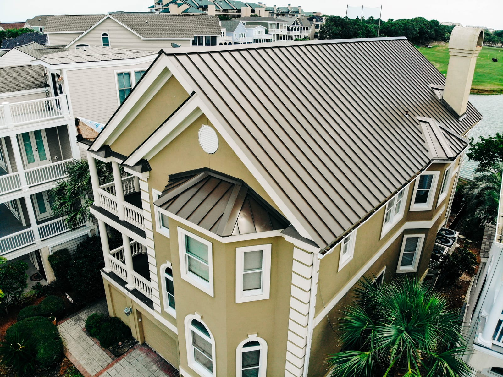 Bronze standing seam metal roof on a tall coastal home with porches
