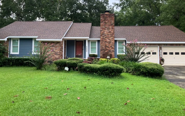 Brick ranch home with a new asphalt shingle roof and a wide green lawn