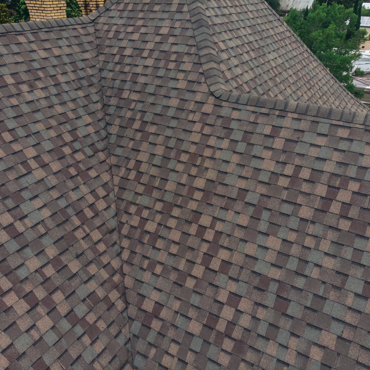 Close-up of blended brown architectural shingles at a roof valley