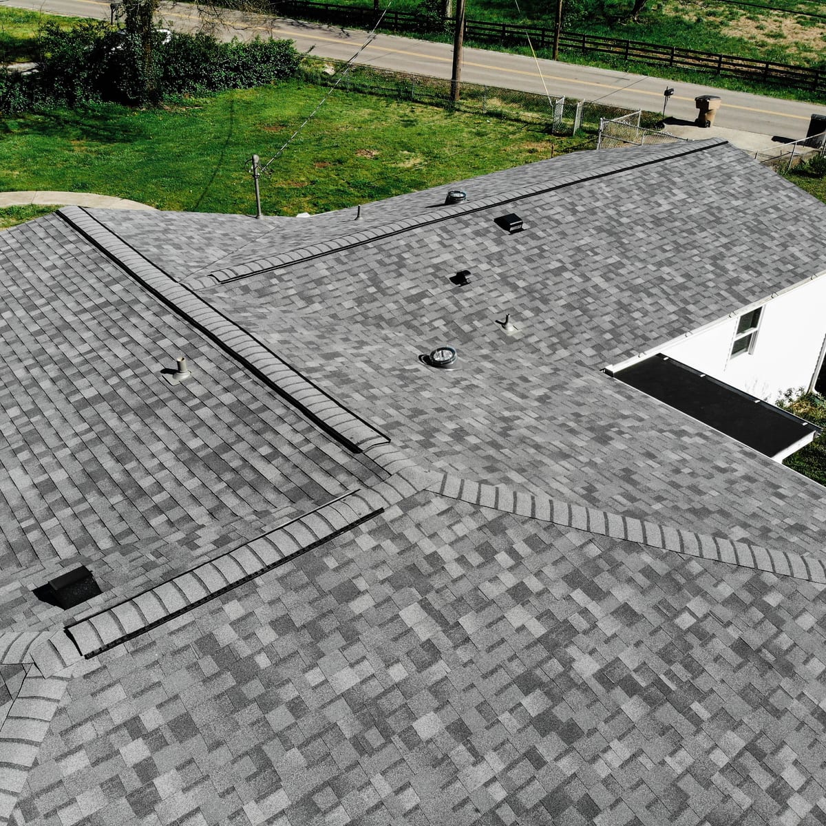 Gray architectural shingles with ridge and hip caps on a new roof