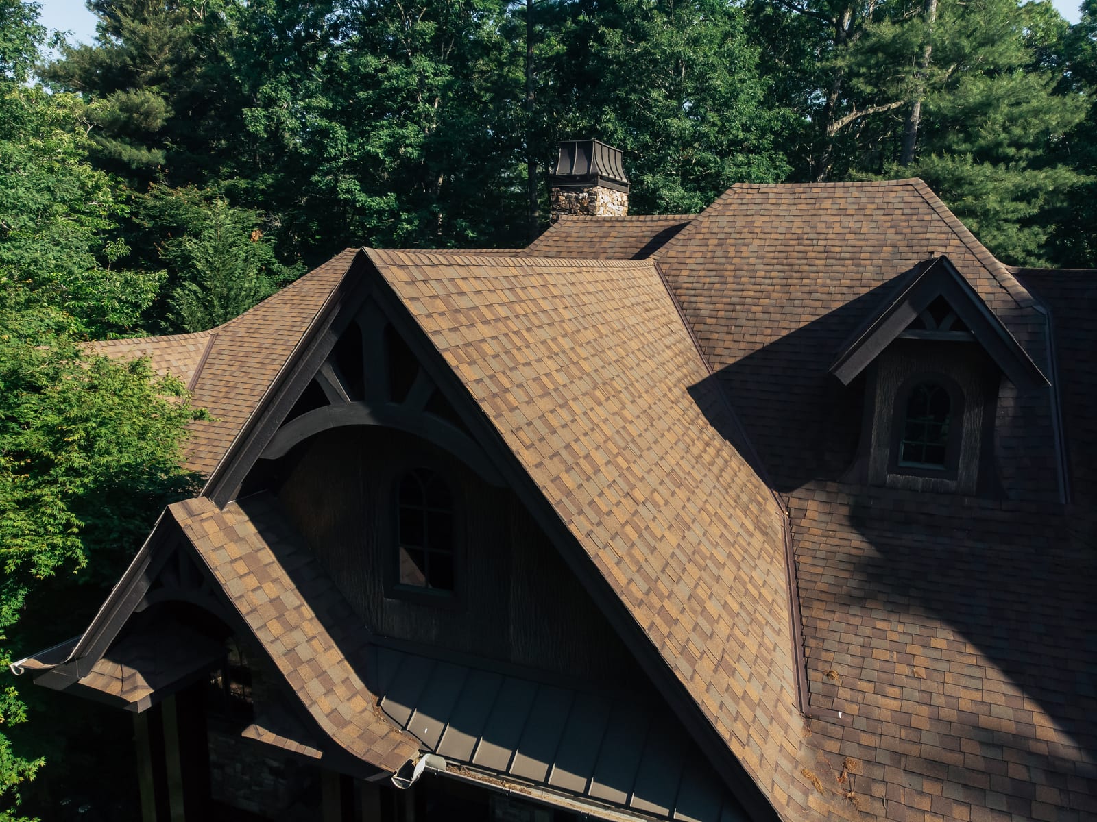 Brown architectural shingles on a craftsman gable with heavy timber brackets
