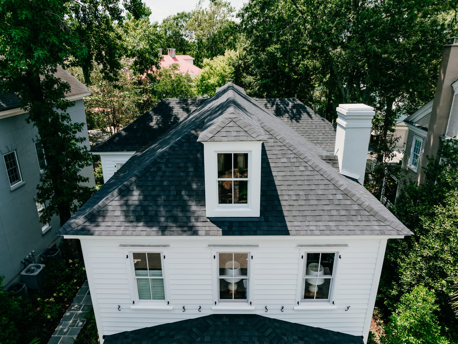 Charcoal architectural shingle roof with a dormer on a white two-story home