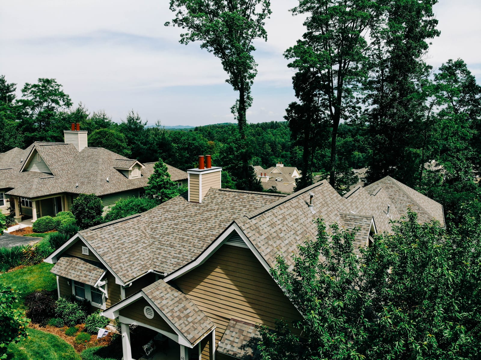 New shingle roofs on homes in a wooded mountain neighborhood