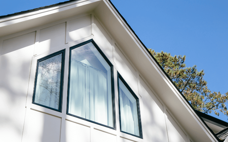 house with white siding and black windows with blue sky