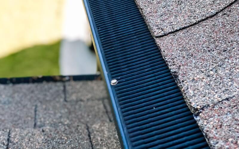 close up of a roof line and gutter with a gutter guard