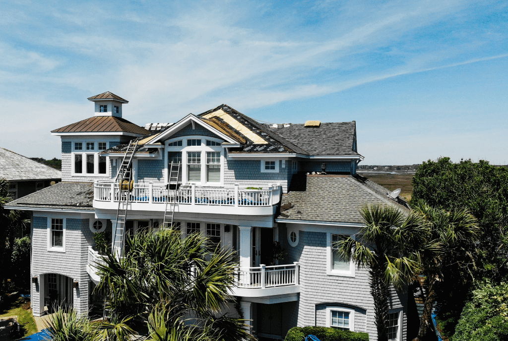Beach house that is in the progress of getting a new asphalt roof on a sunny day