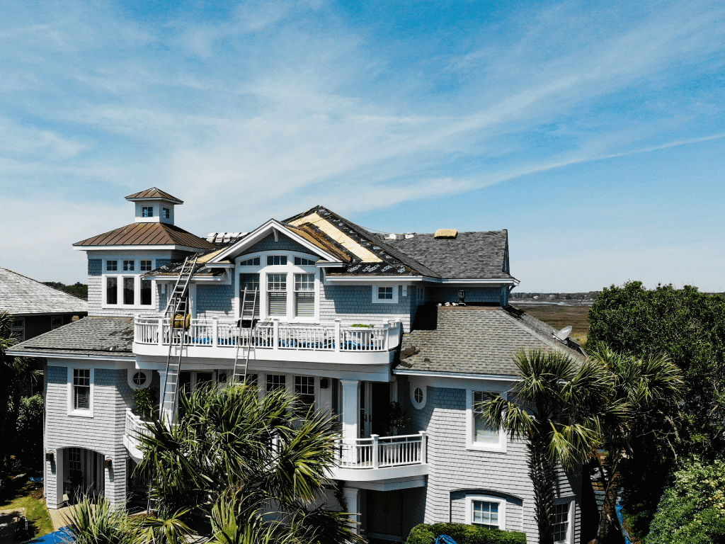 Beach house that is in the progress of getting a new asphalt roof on a sunny day