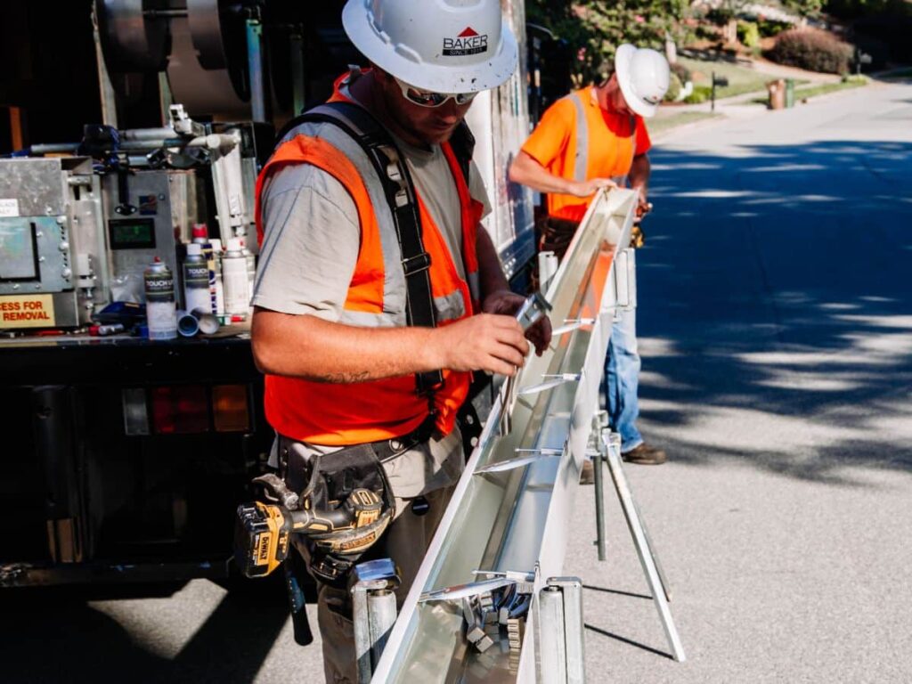 male creating seamless gutters on site out of a truck