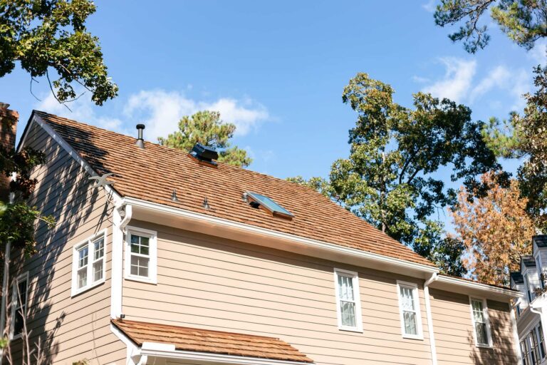 Tan vinyl siding and skylight installed on cedar roof