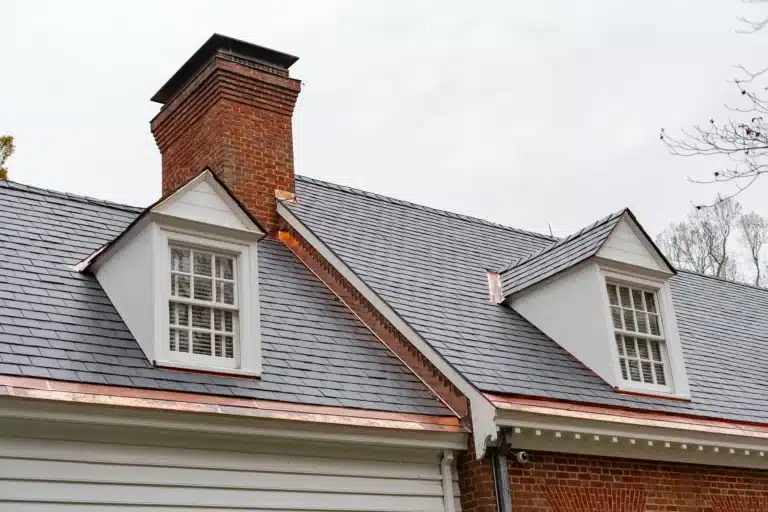 Shingle roof with copper accents on brick home