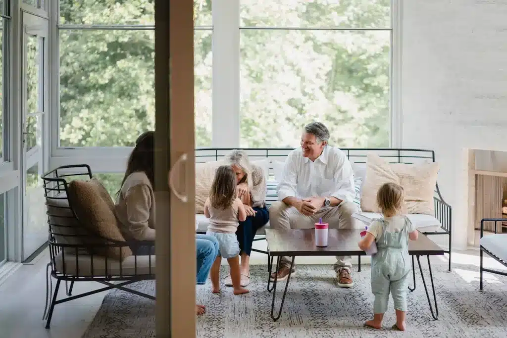 Decorative image of family gathered on a porch by large windows