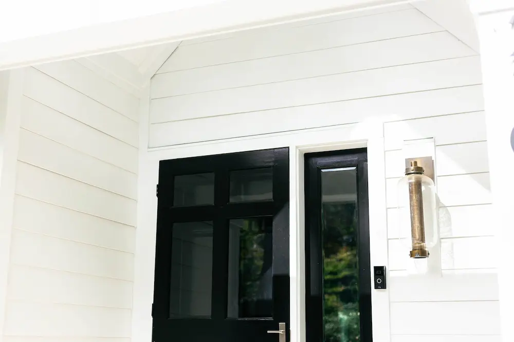 White siding with new black doors on a home
