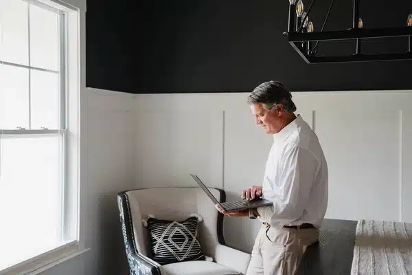 Man using a computer to do research in his living room